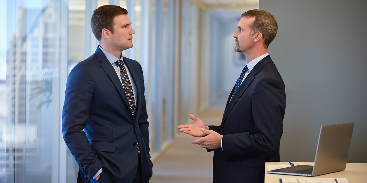 Two associates talking in a conference room.